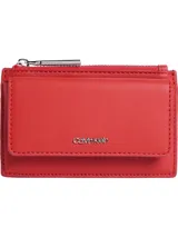 Tarjetero minimalista de color rojo, con cierre de solapa frontal, bolsillo exterior con cierre de cremallera para monedas y múltiples ranuras interiores para tarjetas. Presenta un mini logotipo metálico de Calvin Klein en el frente.