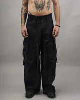 Pantalón cargo negro de gabardina, corte amplio, con múltiples bolsillos y tiras ajustables.