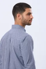 Camisa de manga larga con estampado de cuadros pequeños en tonos rojo, azul y blanco. Presenta cuello abotonado, cierre frontal con botones y un bolsillo pequeño en el pecho.