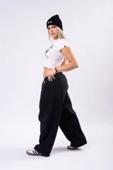 Pantalón de estilo deportivo confeccionado en tela con friza, de corte ancho y tiro medio con cintura elástica y cordón de ajuste.