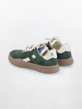 Zapatillas bajas de cuero color marrón con detalles en beige y suela color caramelo.