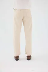 Pantalón de lino color beige, de corte recto y tiro medio, con bolsillos laterales y detalles de costuras visibles.