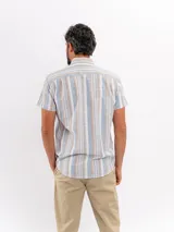 Camisa de manga corta efecto lino de Cuatroases, con estampado de rayas verticales en color azul y fondo beige. Presenta cuello camisero clásico y cierre frontal con botones blancos.