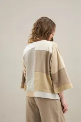 Blusa de diseño patchwork en tonos beige, blanco y tostado, confeccionada con recortes de lino y algodón, cuello redondo, mangas cortas y calce relajado.