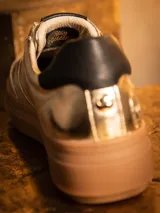 Championes de cuero metalizado en color dorado, con diseño inspirado en C-3PO. Presentan cordones al tono, suela de goma tipo plataforma en color marrón y detalles de marca Star Wars en la lengüeta y el frente.