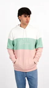 Hoodie de diseño tricolor con bloques horizontales en blanco, verde menta y rosado. Presenta capucha con cordones ajustables, bolsillo tipo canguro frontal y el logo de la marca bordado en el pecho.
