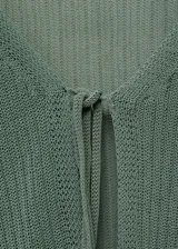 Cardigan de punto canalé color verde oliva, con diseño entallado, cuello de pico y cierre frontal mediante lazos. Incluye una musculosa a juego del mismo tejido y color.