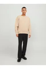 Buzo color beige de manga larga y cuello redondo, con calce relajado y hombros caídos.