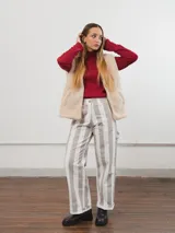 Pantalón de tiro alto con rayas verticales grises y blancas, corte recto y ruedo con dobladillo.