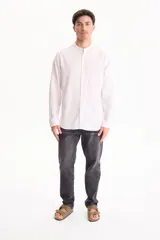 Camisa de manga larga color beige con cuello mao y cierre frontal con botones.