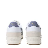 Championes urbanos Puma modelo Shuffle Downtown OG, de diseño retro con base blanca, detalles en gris azulado y puntera de gamuza en tono beige. Cuenta con suela de goma color caramelo y logo de la marca en dorado.