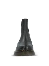 Botin estilo chelsea de cuero negro con paneles elásticos laterales, suela de goma dentada con costuras amarillas contrastantes y tirador trasero.