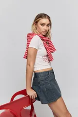 Minifalda de jean azul con diseño de tablas y patrón de rayas verticales finas. Presenta un corte corto y bolsillos laterales.