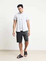 Camisa de manga corta con rayas verticales blancas y grises, cuello abotonado y corte clásico.