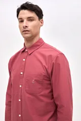 Camisa de corte regular fit confeccionada en algodón, con cuello clásico, cierre frontal de botones y bolsillo en el pecho con detalle bordado.