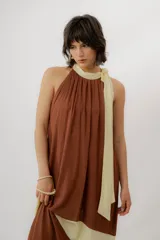 Vestido largo color marrón con detalles en tono marfil, escote halter y lazo largo en el cuello.