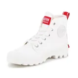 Botas de caña alta Palladium, confeccionadas en lona blanca con suela de goma dentada. Presentan detalles en rojo en la lengüeta, el talón y una etiqueta lateral, junto con texto impreso en el lateral exterior.
