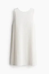 Vestido corto sin mangas en punto suave con textura, de color blanco. Modelo con cuello redondo, espalda superescotada y pollera con leve vuelo, con ribete festoneado en cuello y sisas.
