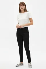 Pantalón jean skinny de tiro medio, color negro, de corte ajustado al cuerpo.