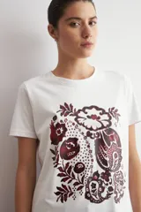 Remera blanca de manga corta con estampado frontal de diseño damasco floral en tonos bordó y marrón.