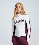 Campera deportiva de corte ajustado, color blanco con paneles laterales y detalles en mangas color bordó. Presenta cierre frontal completo, cuello alto y estampa con lettering 'Oregon' en el pecho.