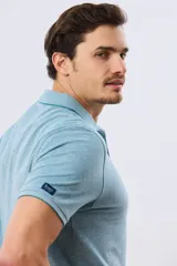 Remera polo piqué de algodón color amarillo, con cuello y puños acanalados, y cierre frontal de botones.