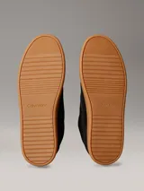Zapatillas Calvin Klein de perfil bajo elaboradas en ante negro, con suela cupsole de goma marrón. Presentan detalles en contraste de color blanco en el talón y la lengüeta, además del monograma 'ck' bordado en el lateral.