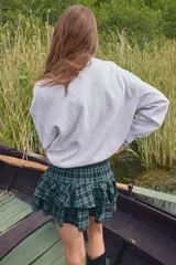 Buzo de cuello redondo con hombros caídos y diseño estampado en el frente. Presenta puños y bajo acanalados, con interior cepillado suave.