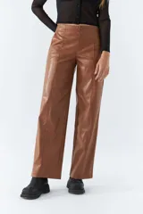 Pantalón marrón de cuero sintético, tiro medio, corte recto cropped y detalle de costuras verticales.