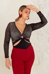 Body negro de encaje elastizado con mangas largas y transparencias. Busto forrado en LYCRA® color crudo, aro en el escote y broches en la entrepierna con fundillo de algodón.