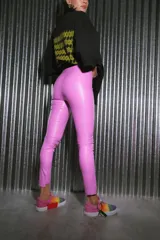 Pantalón largo de ecocuero color lila, con tiro alto, calce ajustado y botamanga irregular.