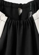 Jardinera larga de lino y viscosa, color negro con detalles de rayas blancas en contraste en los laterales. Cuenta con cuello halter, sin mangas, diseño recto, dos bolsillos laterales y cordón ajustable en la cintura.