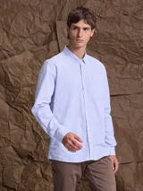 Camisa de corte clásico confeccionada en tejido Oxford de algodón, con diseño de rayas verticales finas en color azul y blanco, cuello abotonado y bolsillo frontal.