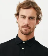 Camisa de hombre de manga larga, color verde oscuro, con cuello camisero y cierre frontal de botones blancos. Corte comfort.