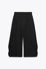 Pantalón fluido de tiro bajo con cintura elástica, confeccionado en tejido ligero con caída, de corte amplio y diseño minimalista.