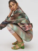 Calza deportiva 3/4 de tiro alto, confeccionada en lycra con un diseño estampado abstracto en tonos tierra, verdes y rosados.