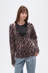 Cardigan de punto con estampado animal print en tonos rosado y negro, de manga larga y escote en V.