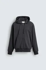 Sudadera de corte relajado confeccionada en tejido compacto de algodón con interior forrado, cuello con capucha, manga larga, bolsillos frontales tipo canguro y acabados en rib.
