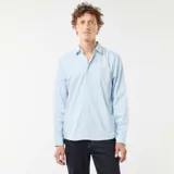 Camisa de manga larga celeste con estampado de pequeños lunares oscuros, corte regular, cuello camisero clásico y cierre frontal de botones.