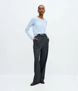 Pantalón de corte recto confeccionado en punto roma con estampado de cuadros. Presenta cintura estructurada con pliegues delanteros, trabillas para cinturón y cierre frontal. Incluye un cinturón fino con hebilla metálica.