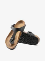 Sandalias Birkenstock modelo Gizeh, color negro, con tira de cuero engrasado y hebilla metálica ajustable.