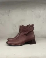 Bota corta de cuero color bordeaux con taco bajo y costuras hechas a mano.