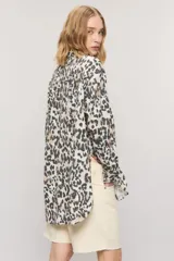Camisa oversize de algodón con estampado animal print, cuello camisero, manga larga y cierre frontal con botones.