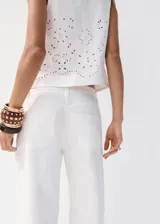 Jeans blancos de silueta balloon, tiro regular y largo standard, con detalles bordados sutiles en las perneras.