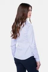 Camisa lisa de color blanco, de corte clásico y entallado, con mangas largas y cierre frontal con botones.