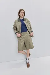 Bermuda de algodón color verde militar, de calce amplio y largo a la rodilla. Cuenta con bolsillos utilitarios delanteros, pinzas y cierre frontal con botones.