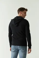 Campera gris de felpa con capucha, cierre frontal, bolsillos laterales con cierre, puños elásticos y logo bordado en el pecho.