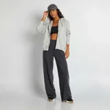 Buzo gris con capucha, cierre frontal con cremallera y bolsillos tipo canguro.