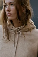 Sudadera de manga larga con capucha ajustable mediante cordones, bolsillo frontal tipo canguro y puños y ruedo en tejido rib.