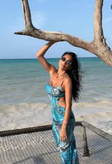 Vestido midi de microtul con estampado de mariposas en tonos azules. Presenta un diseño ajustado con aberturas laterales en la cintura, escote recto y breteles finos.